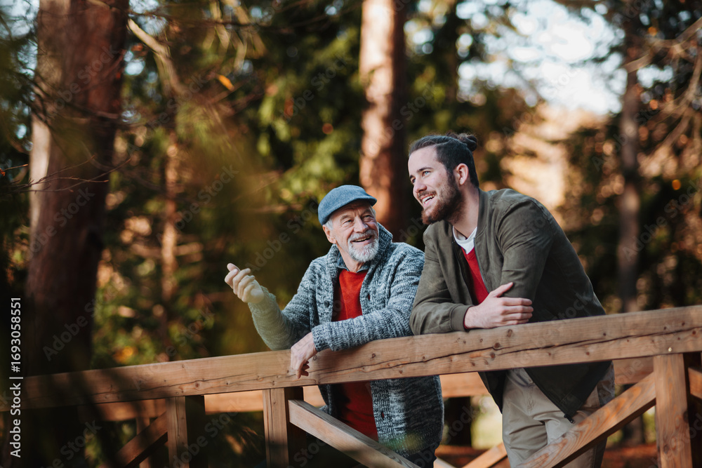 © Halfpoint - Older father and his son standing on bridge, looking at nature. © Halfpoint - Older father and his son standing on bridge, looking at nature.