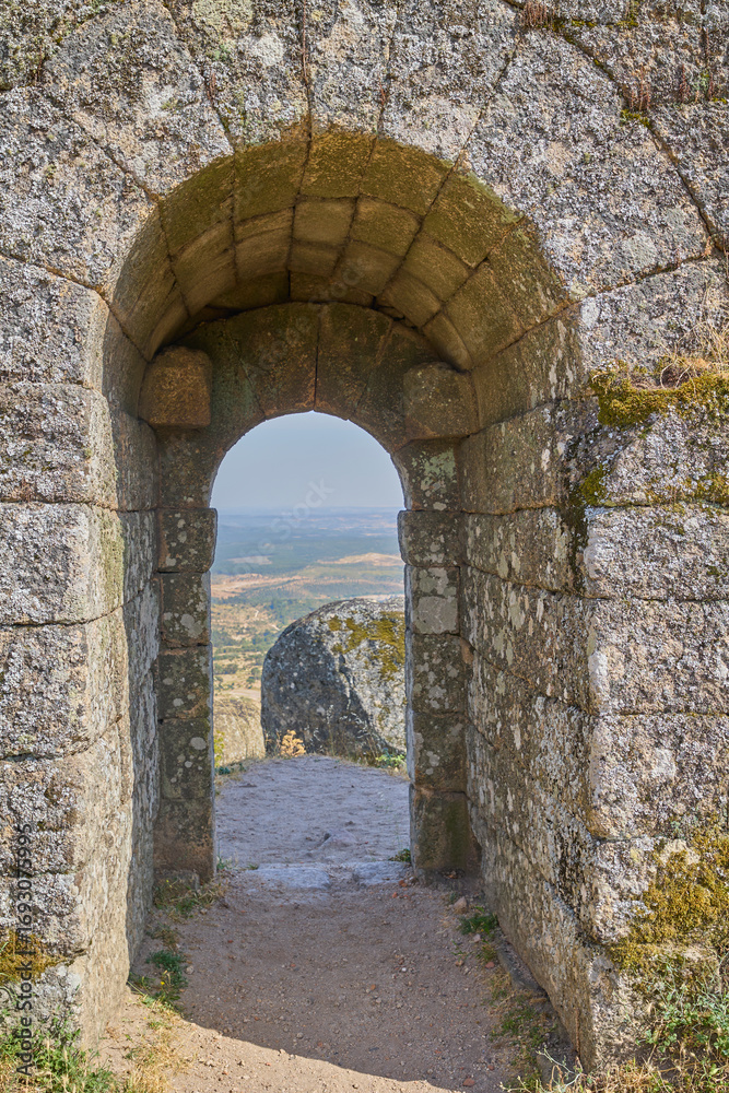 Fototapeta premium Ancient stone arch with view of landscape and mountains in Monsanto, Portugal.