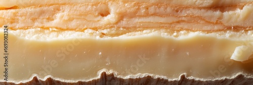 Layers of artisanal cheese showcasing naturally formed textures and colors under soft light in a rustic setting, perfect for culinary enthusiasts