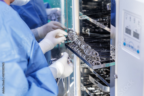 Obraz na plátne Technician loading surgical tools into autoclave for hospital sterilization