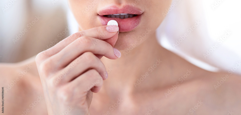 Fototapeta premium Body, beauty and health care, vitamins, birth control, pain relievers, antidepressants and home treatment during covid. Millennial woman in towel takes pill in morning, close up, cropped, copy space