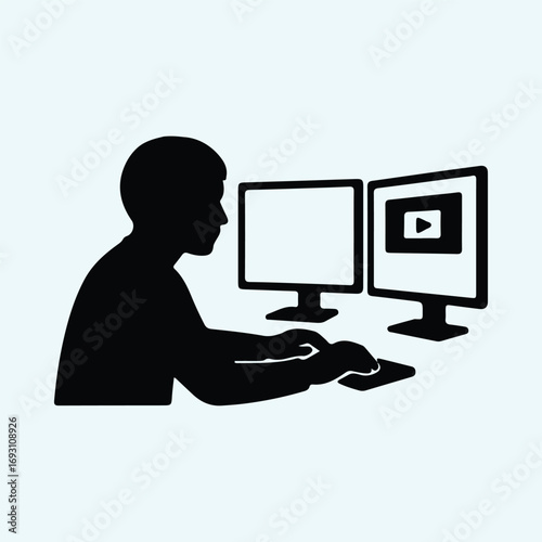 Illustrator Vector Programmer working on two monitors at the desk silhouette