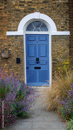 Blue door in a brick building with flowers