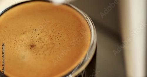 Last drop of a espresso falling from the coffee machine while brewing