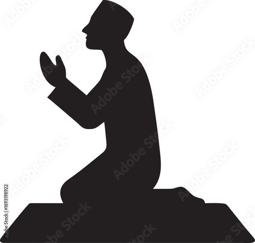 Silhouette of a muslim man kneeling and praying on a prayer mat devoutly