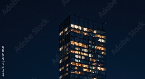 Modern Dark Skyscraper with Warm Interior Lights at Night