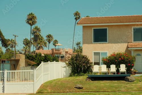 Idyllic two story california house with four chairs in front yard at Sunset cliffs in ocean beach san diego california during summertime