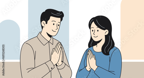 Smiling man and woman greet each other with hands clasped together in a polite gesture.