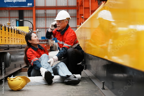 Asian woman, a product inspection worker, had an accident and fell, hurting her ankle, and sat on the factory floor. A senior supervisor came to help, holding a walkie-talkie, and called for help.