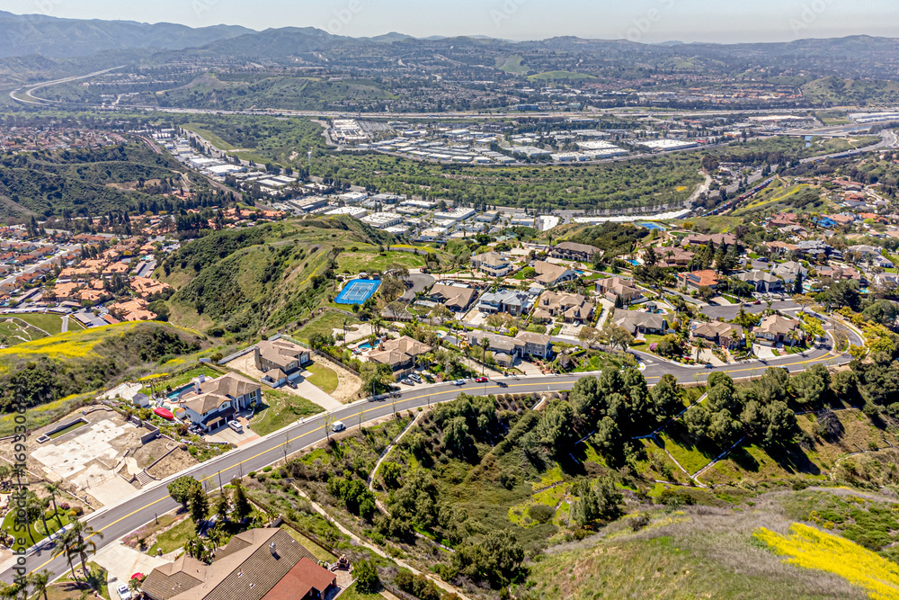 Fototapeta premium Yorba Linda, Orange County, CA, California, April 11, 2024: Aerial Drone City View toward Hidden Hills Road with Homes, Houses, Streets, Mountain Community Villages 