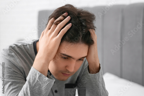 Depressed young man in bedr...