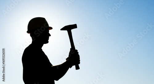 Silhouette of construction worker wearing hard hat holding hammer against a bright blue sky background vreated with genrated ai