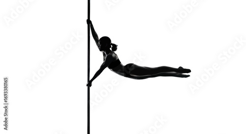 Striking silhouette of a woman performing pole dance acrobatics with strength and grace against a