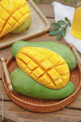 Fresh Cut Mango Cubes in Wicker Basket with Tropical Fruit Display on Wooden Table
