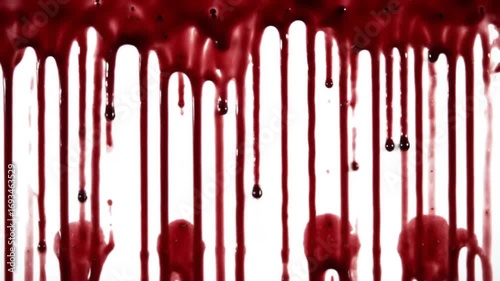 Close-up of red blood dripping down a white background with a dark and ominous mood.