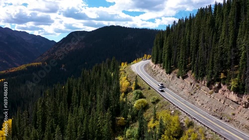 Scenic Road Traffic Through Colorado Mountains During Autumn Foliage Drone