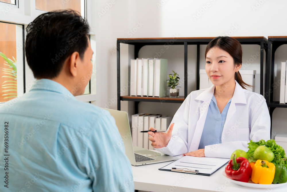 Fototapeta premium Asian nutritionist consulting patient in clinic, meal plan discussion, healthcare advice, weight loss support, doctor talking and explaining patient for nutrition consultation, wellness care.