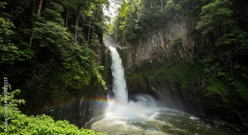 Majestic cascade in a vibrant rainforest with mist and sunlight creates a rainbow
