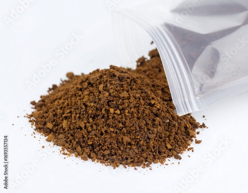 Ground coffee spills from a clear bag