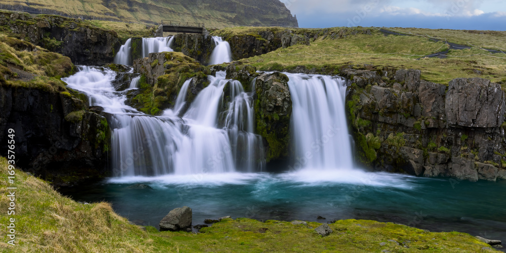 Fototapeta premium Low angle view of the Kirkjufellsfoss water fall near Grundarfjordur town in Iceland
