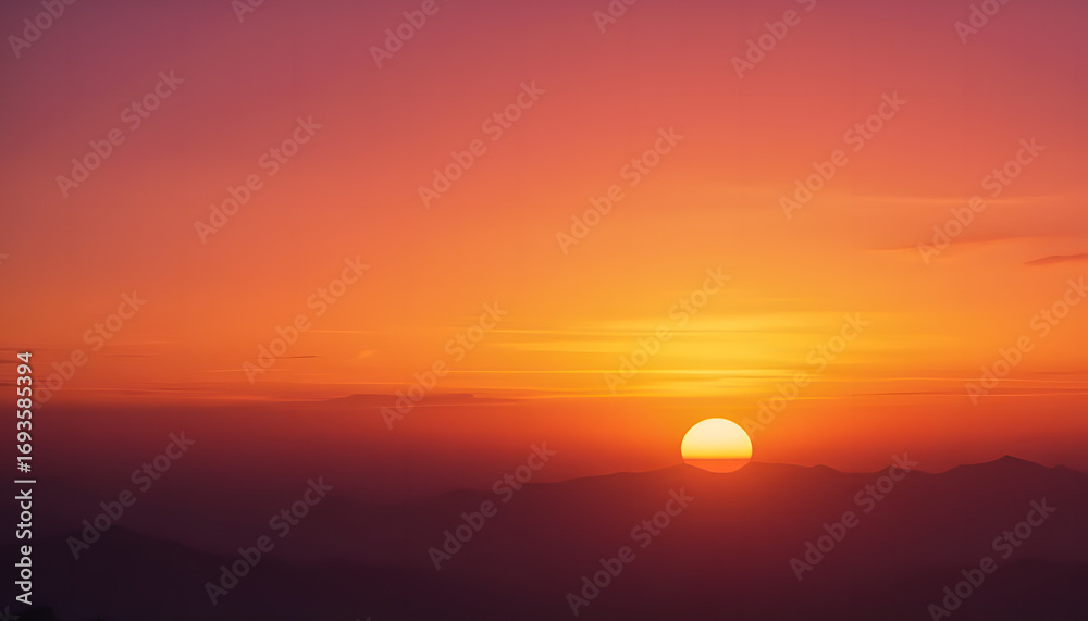 Obraz premium A tranquil scene with the sun setting behind distant mountains, radiating a golden glow.