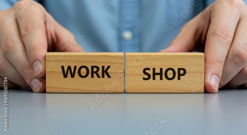 Workshop: A pair of hands carefully places wooden blocks spelling WORKSHOP, highlighting the concept of collaboration and craft.