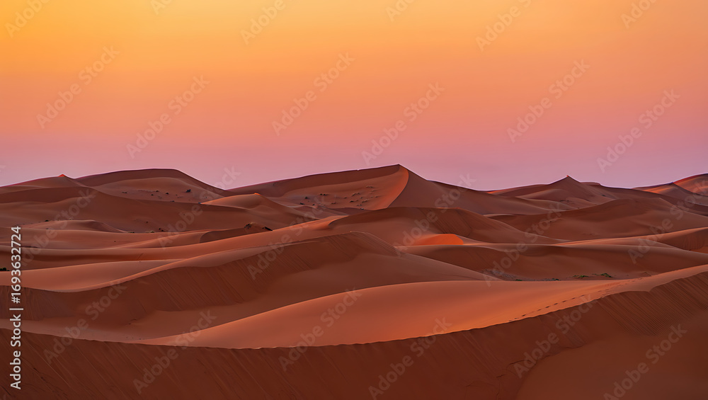 Fototapeta premium Fiery orange and red hues paint the dramatic Sahara landscape, as the sun dips below the rolling sand dunes