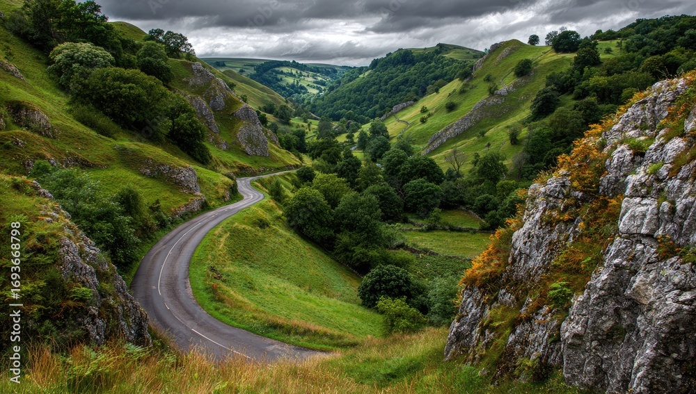 Fototapeta premium Scenic winding road through a lush valley under a dramatic sky