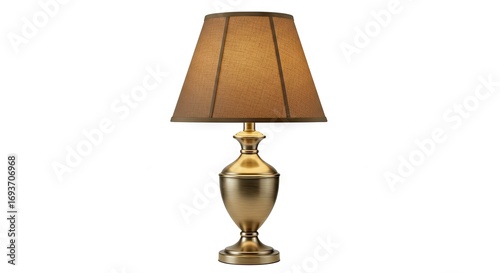 An antique brass table lamp with a brown fabric shade stands on a white background