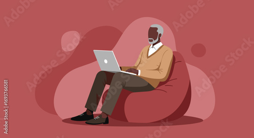 Senior man working remotely on a laptop, comfortably seated on a beanbag. Represents modern retirement, online learning, or digital connectivity.