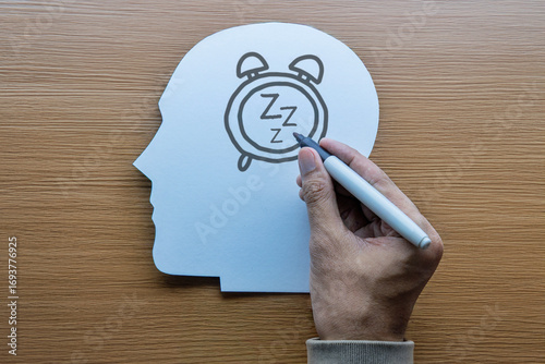 A hand drawing an alarm clock with 