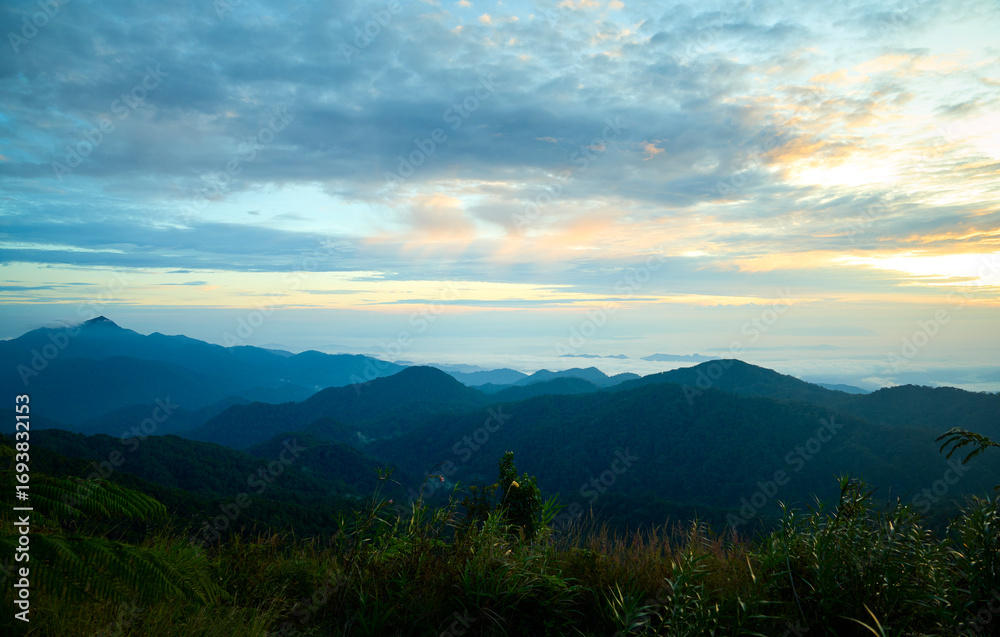 Obraz premium Sunrise illuminating lush mountain ranges in genting highlands, malaysia