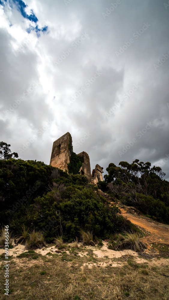 Fototapeta premium Ruined stone tower on a hill