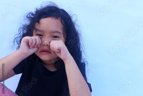 The Asian girl cried with her hands clenched close to her eyes.