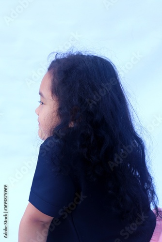 Asian girl showing long curly hair.