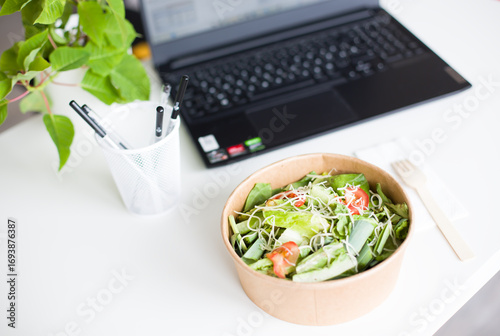 Home Delivery Salad Bowl Near Laptop on Work Desk