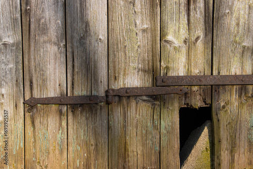 Rustic Wooden Barn Door With Weathered Planks and an Old Metal Hinged Lock