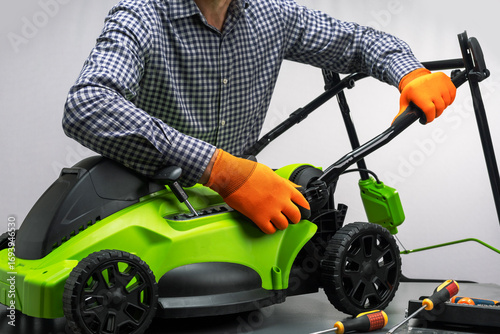  A man assembling a new, unboxed lawn mower.