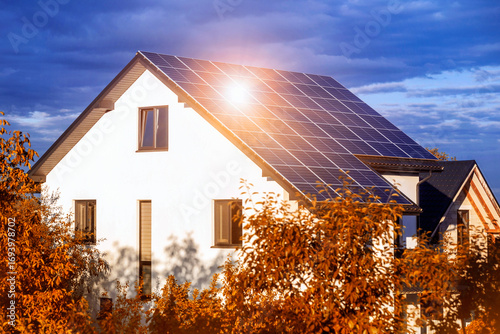 Solar Panels House Roof in Autumn with Sun. Solar Panel Station of Residential Building on Fall Yellow Background.