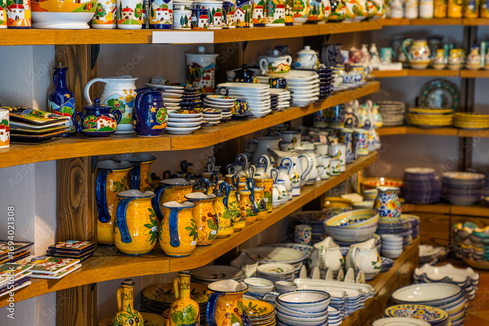 Obraz premium Typical souvenirs in a shop in historic village San Gimignano, Tuscany, Italy. Detail of a local shop in the streets. Traditional souvenirs of ceramics. Europe tourism or vacation travel concept.