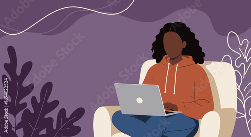 Young African American woman working or studying comfortably from home on her laptop. Perfect for remote work, online learning, or digital lifestyle concepts.