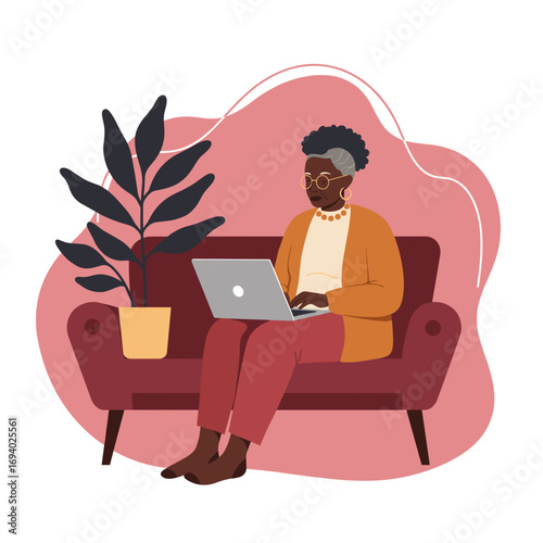 Senior African American woman comfortably engaged with a laptop at home. Represents modern digital living, remote work, and accessible technology for the elderly.