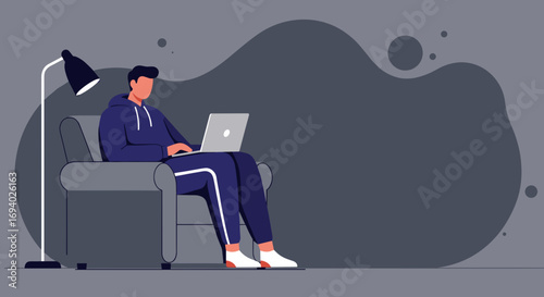 Young man working remotely on a laptop from the comfort of his armchair at home. Ideal for concepts of remote work, online education, or modern lifestyle.