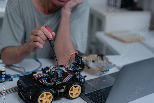 Fotografia Robotics engineer assembling components of a robot car using a screwdriver and a