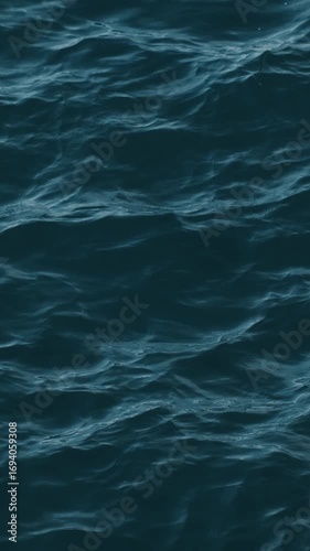 Calm Adriatic Sea waves near Budva, Montenegro. Gentle ripples on deep blue water. Vertical 4k footage. Minimalistic animated background