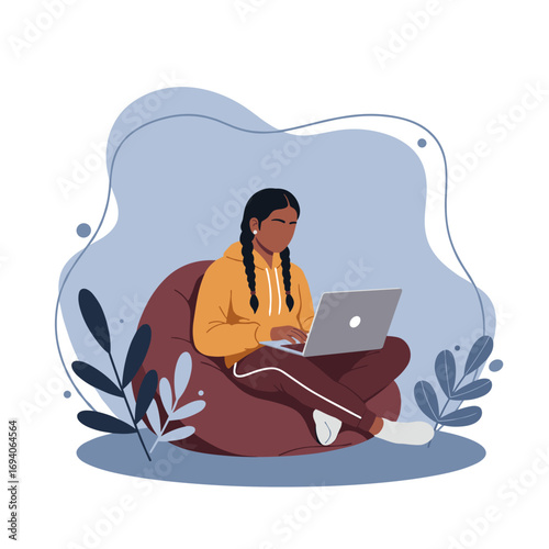 Young woman comfortably using a laptop on a beanbag chair, symbolizing remote work, online education, or digital leisure in a cozy setting.