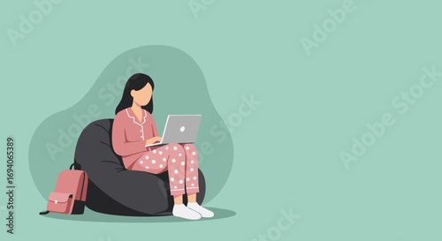 Young woman in pajamas comfortably using a laptop on a bean bag chair at home. Concept of remote work, online learning, or casual leisure.