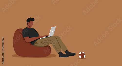 Casual male working remotely on a laptop from a comfortable bean bag at home. Blending work and leisure in a relaxed setting.