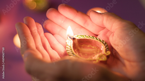 hand carrying glowing festival diya