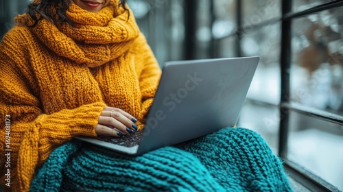 Person working on laptop in cozy winter setting